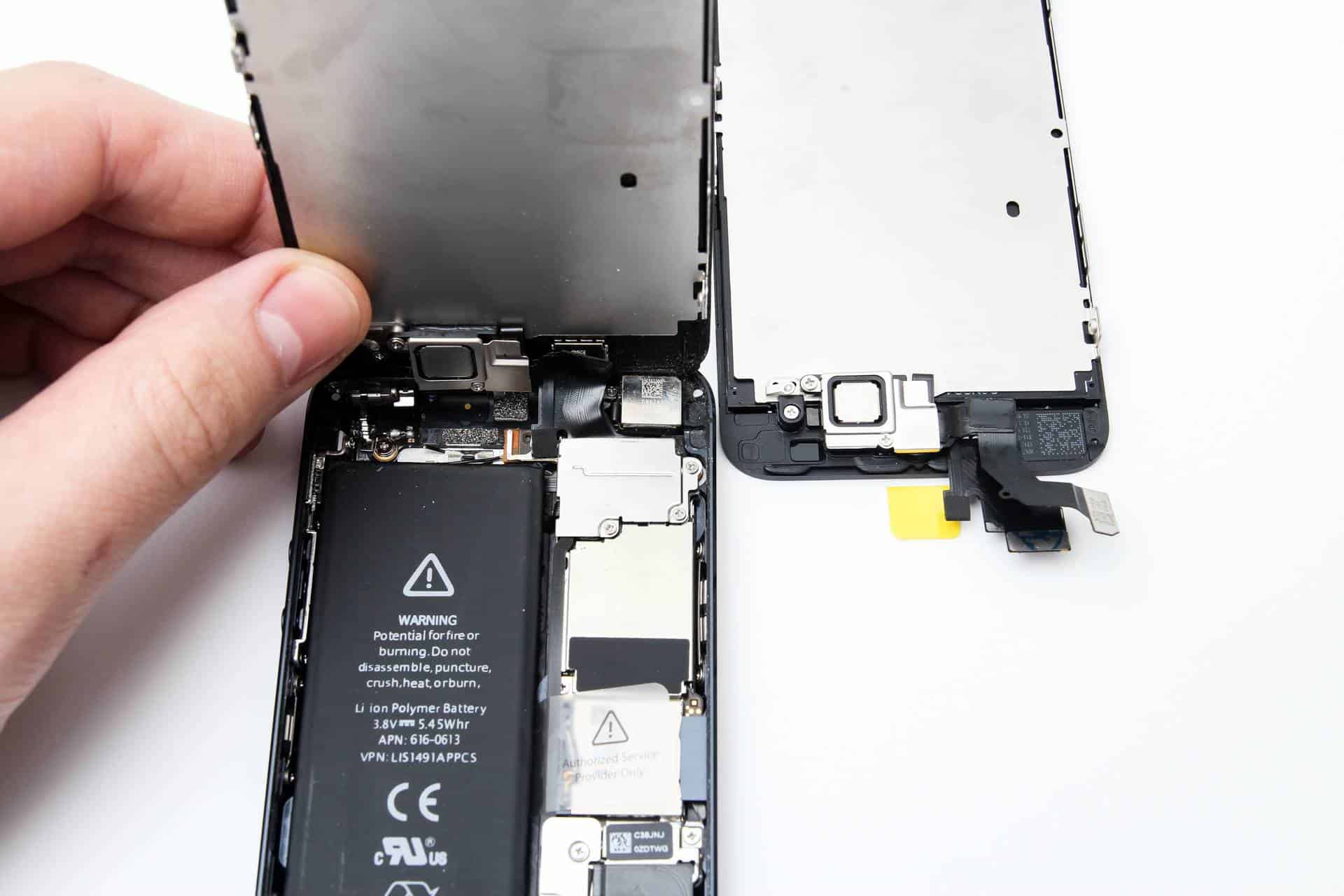 An opened iPhone on the bench with the shielding off and the battery connector exposed