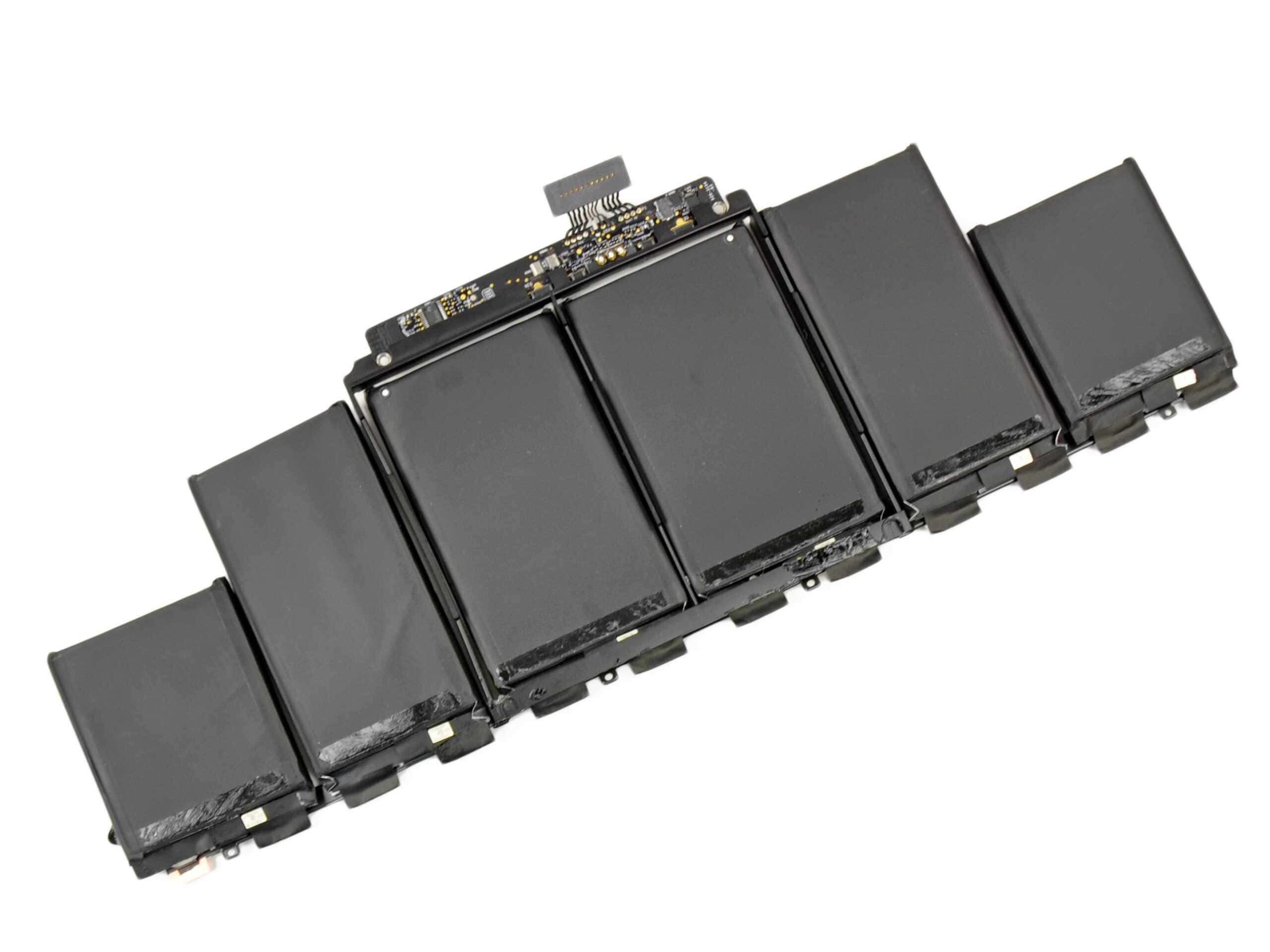 A MacBook Pro Retina battery: six flat lithium cells joined by a control board, laid out before fitting