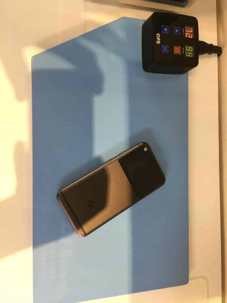 A phone warming on a heat mat so the screen adhesive softens before removal