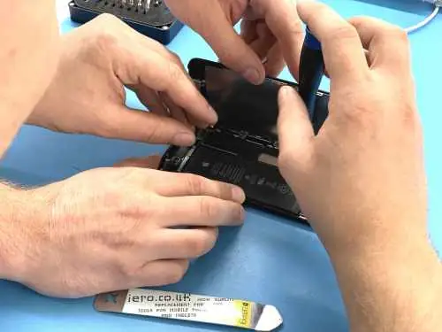 Two Fixfactor technicians opening an iPhone on the repair bench