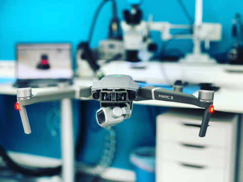 A DJI Mavic 2 on the repair bench in front of a microscope at Fixfactor