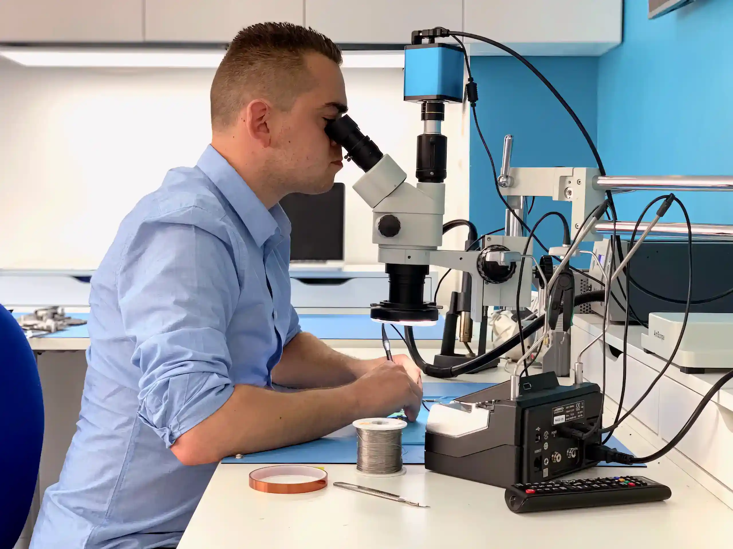 Fixfactor technician performing microsoldering repair under microscope