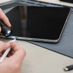 Technician inspecting an iPad USB-C charging port under a work light