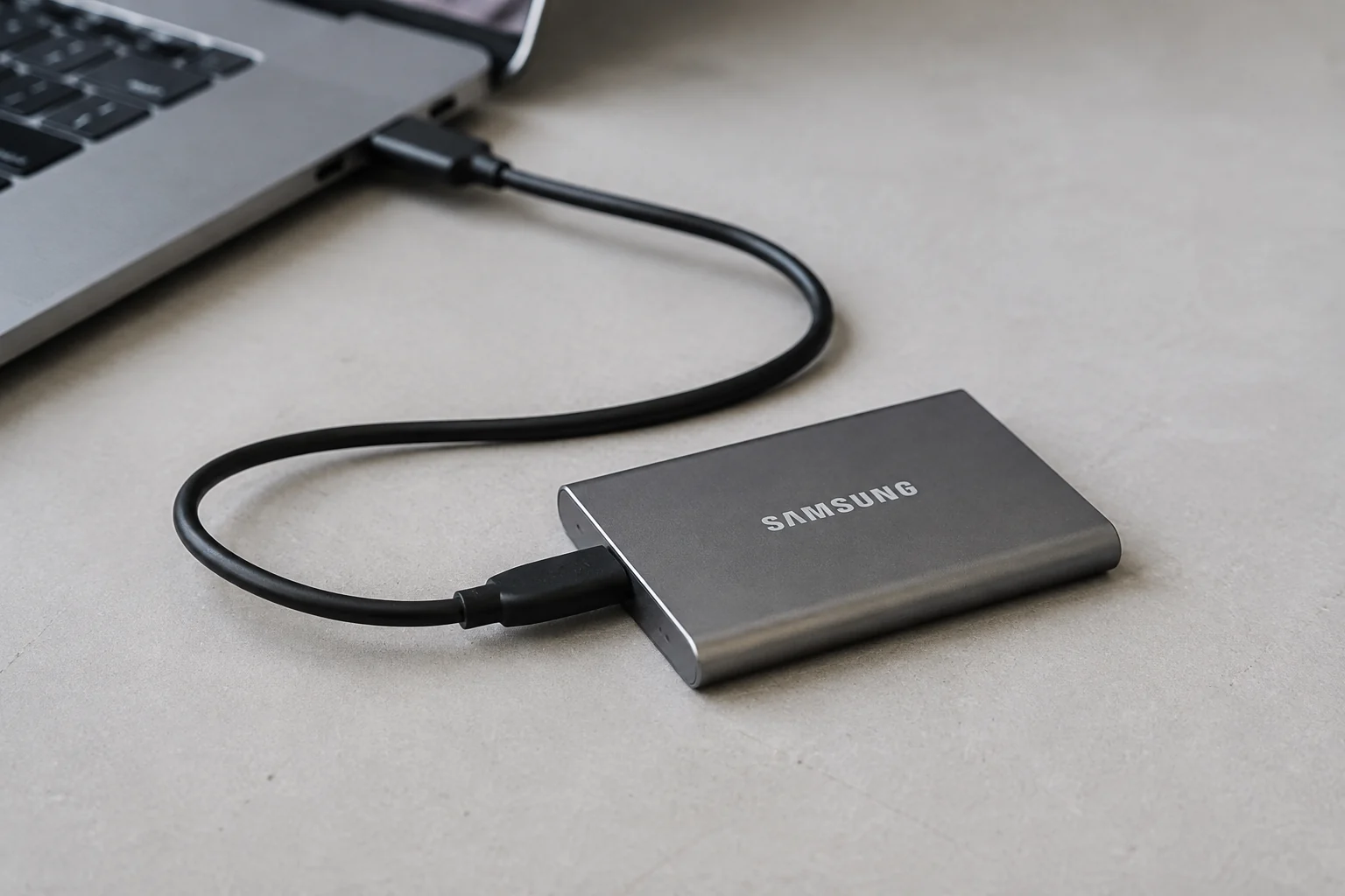 Illustration of a portable SSD connected to a laptop for backup