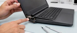 Technician inspecting broken mounting points around a laptop hinge